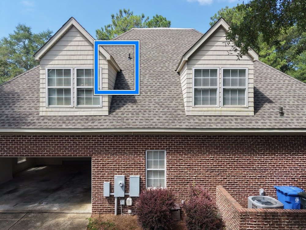 Exterior view of a dormer valley above a garage on a brick home