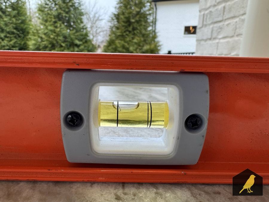 Level tool showing a backward pitch on a stone counter