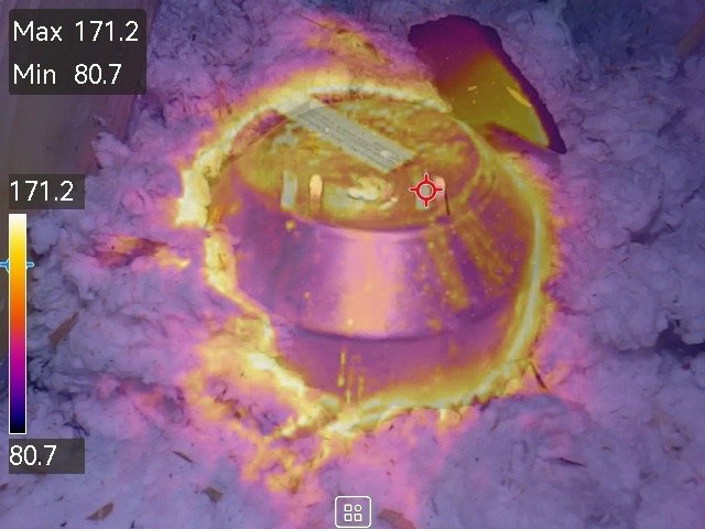 Thermal image showing a hot recessed light fixture surrounded by attic insulation