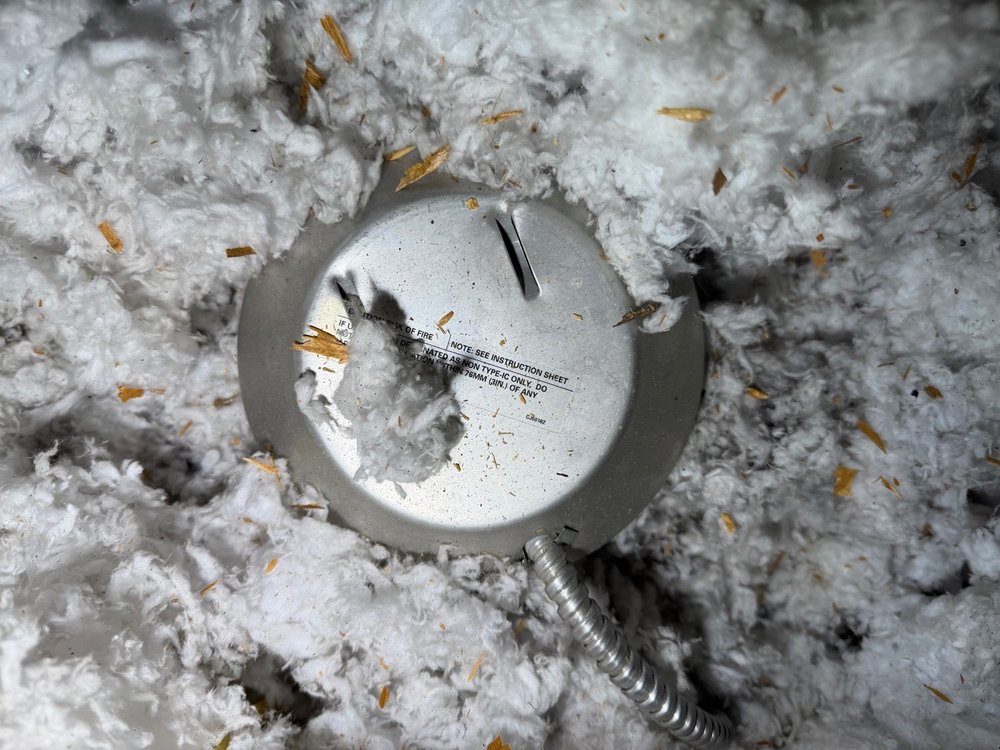 Recessed light fixture packed in attic insulation