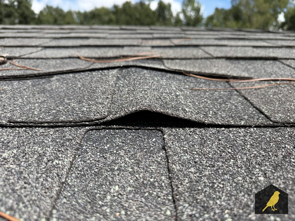 Tented shingle tab from a nail pop underneath